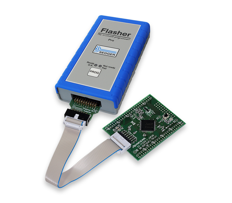 RL78 Adapter The image shows a programming device labeled "Flasher Pro" with a blue rubber casing. Attached is a green circuit board connected via a ribbon cable, used for programming and debugging electronic devices. The interface includes indicator lights and a programming button.